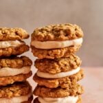 Two stacks of gluten free pumpkin oatmeal cream pies with a creamy brown butter filling in the middle.