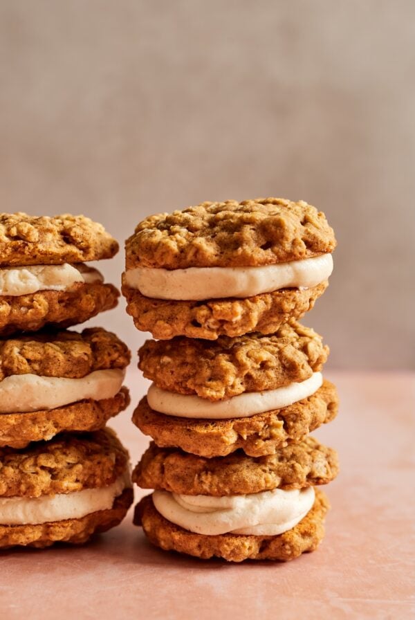 Two stacks of gluten free pumpkin oatmeal cream pies with a creamy brown butter filling in the middle.