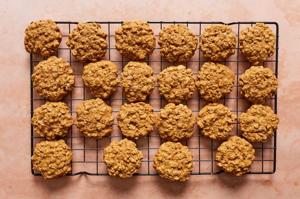 Baked gluten-free oatmeal cookies on a wire rack cooling before filling.