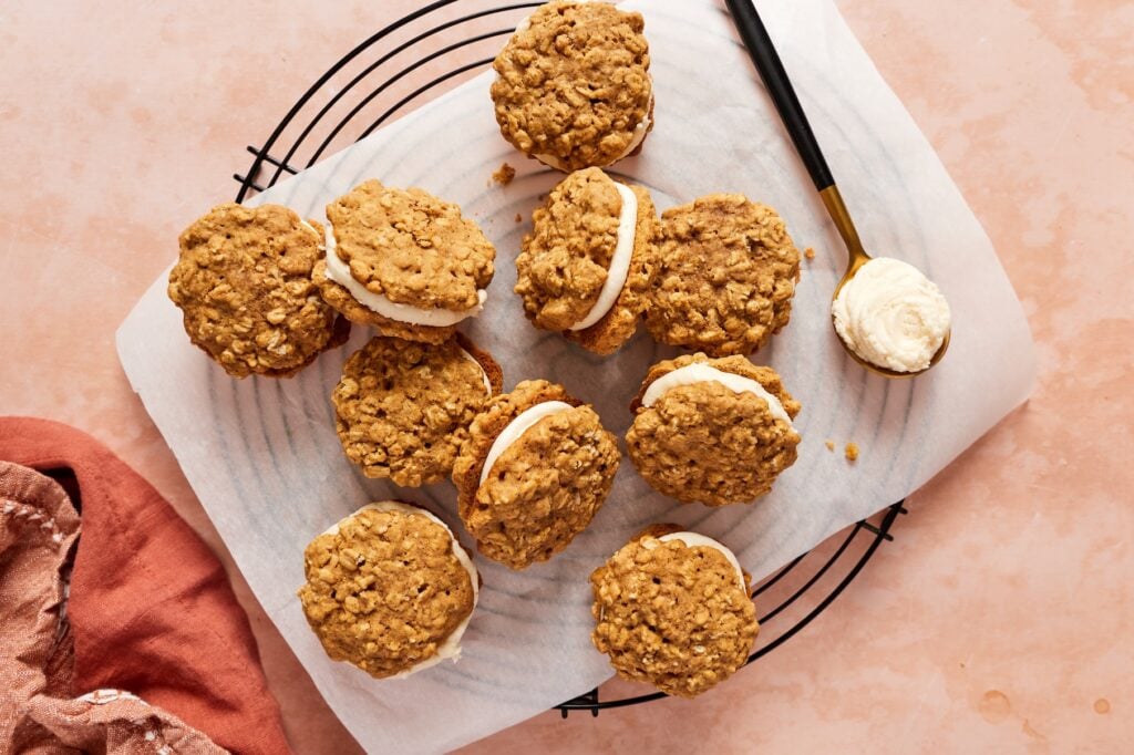 Filled gluten-free pumpkin oatmeal cream pies on a sheet of parchment paper.
