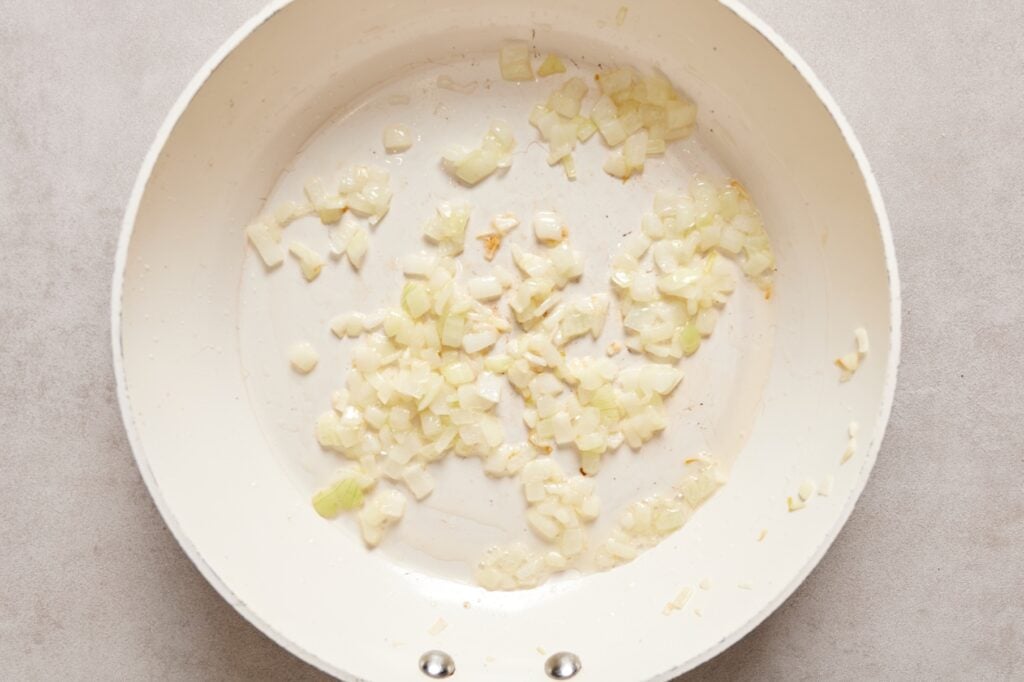 Diced onions in a skillet sauteeing until translucent.