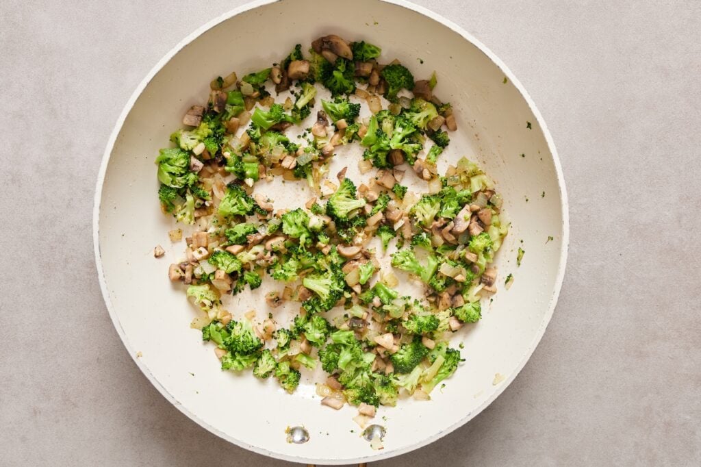 Diced broccoli and mushrooms aded to the onions in the skillet.