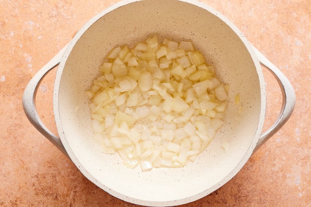 Onions sauteeing in a large soup pot