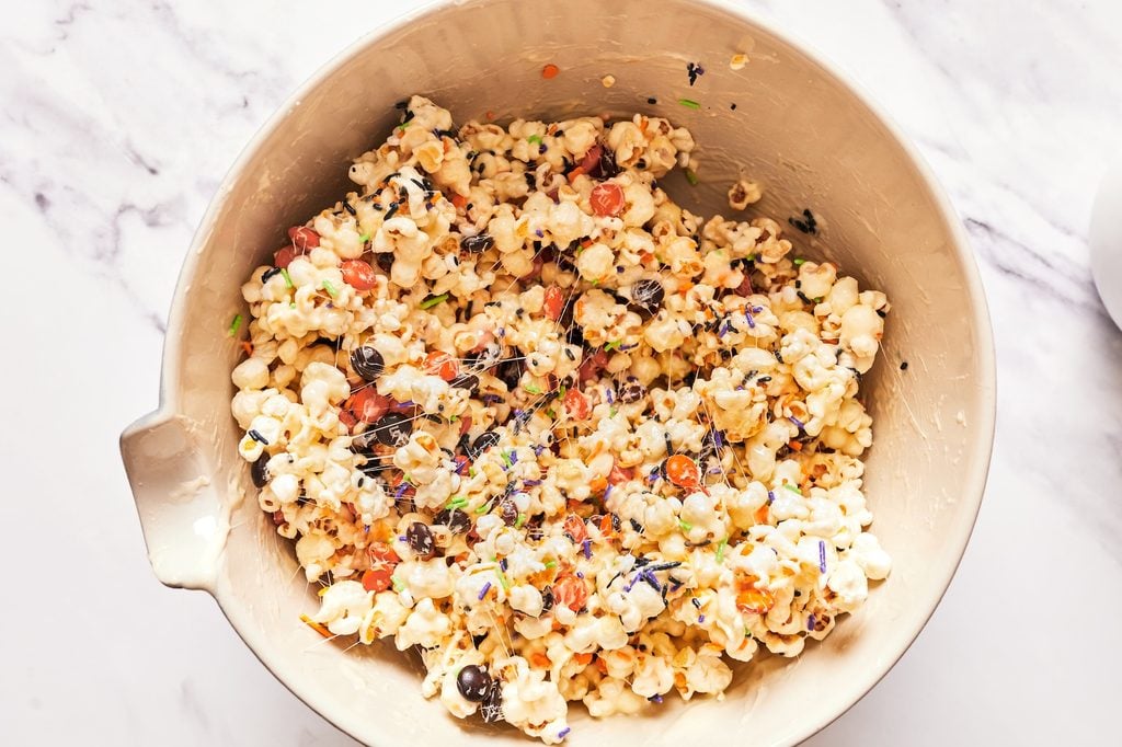 Marshmallow-coated popcorn with whole M&Ms and Halloween sprinkles mixed in