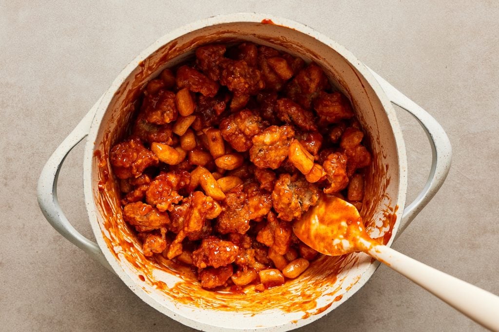 A pot filled with Korean popcorn chicken tossed in a sweet and spicy sauce.